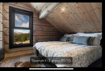 a bedroom with a bed and a window in a log cabin at Flott moderne hytte i Holterdalen, 4 soverom, 2 bad, Jacuzzi, garasje in Rauland