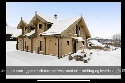 a large wooden house with snow on it at Flott moderne hytte i Holterdalen, 4 soverom, 2 bad, Jacuzzi, garasje in Rauland