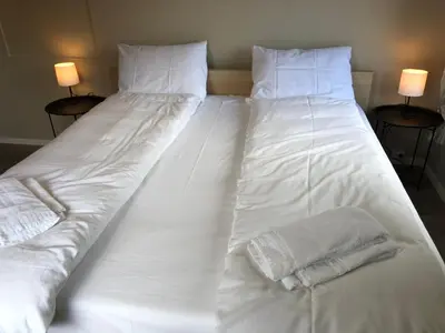 a large white bed with two pillows on it at Jølster Lake View in Årdal