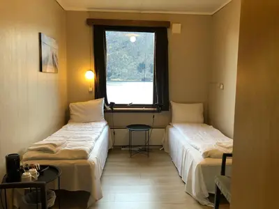 a hotel room with two beds and a window at Jølster Lake View in Årdal
