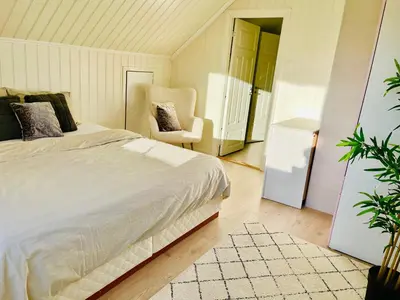 a bedroom with a bed and a chair in it at A beautiful 3-bedroom apartment with stunning views and free parking in Bergen