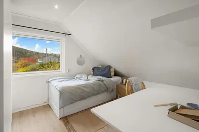 a bedroom with a bed and a window at A beautiful 3-bedroom apartment with stunning views and free parking in Bergen
