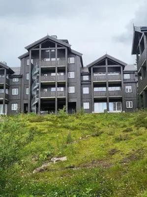 a large building with a green field in front of it at Ski in Ski out Trysil in the mountain of Norway 60m from the Slopes in Trysil