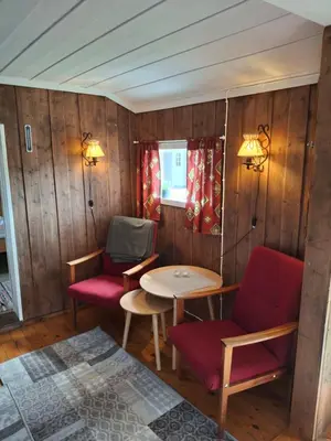 a room with wooden walls and a table and chairs at Bjørgebu Camping AS in Mysusæter