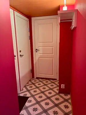 a hallway with a white door and a tile floor at New beautiful flat, parking! in Bergen