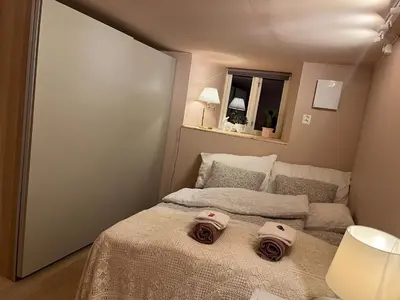 a small bedroom with a bed with two towels on it at New beautiful flat, parking! in Bergen