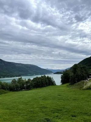 a green field with a view of a body of water at New appartment in Lom inkl bedding in Lom