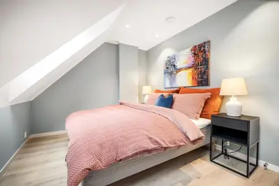 a bedroom with a bed and a painting on the wall at Allmenningen Apartments in Bergen
