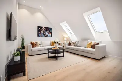 a living room with two couches and a table at Allmenningen Apartments in Bergen