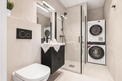 a bathroom with a toilet and a washing machine at Allmenningen Apartments in Bergen