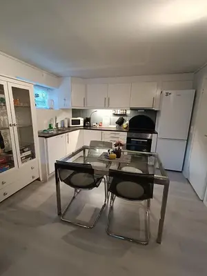 a kitchen with a glass table and two chairs at 3-roms leilighet, innsjekk uten vert. Egen inngang in Ålesund