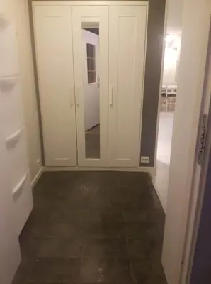 a room with a mirror and white cabinets and a tile floor at 3-roms leilighet, innsjekk uten vert. Egen inngang in Ålesund