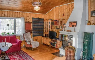 a living room with a red couch and a fireplace at Gorgeous Home In Os I Østerdalen in Os