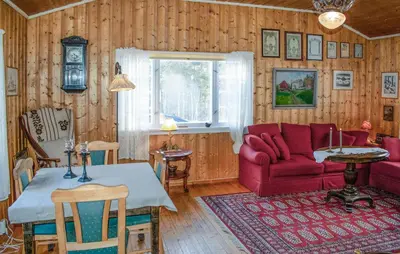 a living room with a red couch and a table at Gorgeous Home In Os I Østerdalen in Os