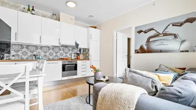 a living room with a couch and a kitchen at Bergen Sentrum: Koselig leilighet med 2 soverom! in Bergen