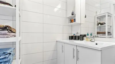 a white bathroom with a sink and a mirror at Bergen Sentrum: Koselig leilighet med 2 soverom! in Bergen
