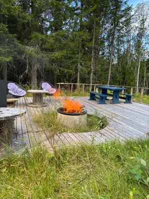 a fire pit and picnic tables on a wooden deck at Hus nær lillehammer og sjusjøen in Lillehammer