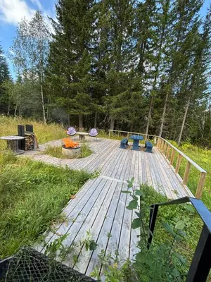 a wooden deck in the middle of a field at Hus nær lillehammer og sjusjøen in Lillehammer