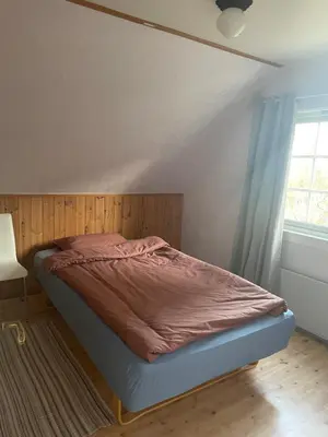 a bedroom with a bed in a room with a window at Krokenes in Sylte