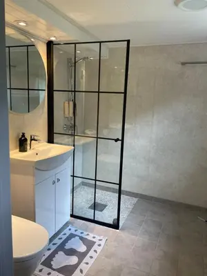 a bathroom with a shower and a toilet and a sink at Krokenes in Sylte