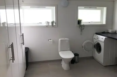 a bathroom with a toilet and a washing machine at Store Ringheim Apartment - Villa Solberg in Vossevangen