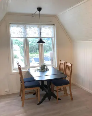 a dining room table with chairs and aendant light at Store Ringheim Apartment - Villa Solberg in Vossevangen