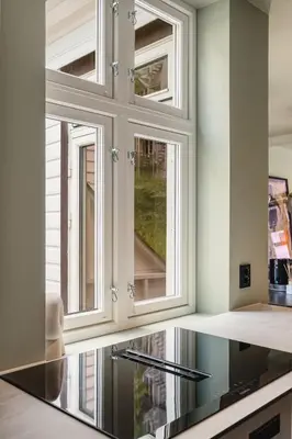 a kitchen with three windows in a room at Bryggen // Fløyen Living in Bergen