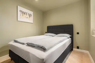 a bedroom with a large bed with a black headboard at Bryggen // Fløyen Living in Bergen
