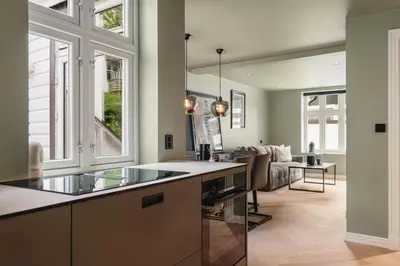 a kitchen with a counter and a living room at Bryggen // Fløyen Living in Bergen
