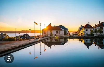 a pool of water with houses and the sunset in the background at Byleilighet nær Fløyen in Bergen