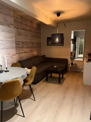 a living room with a couch and a table at Byleilighet nær Fløyen in Bergen