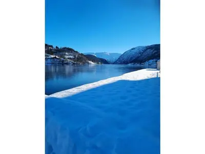 a body of water with snow on the shore at 