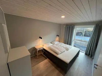 a small bedroom with a bed and a window at Rorbu i Bud Havn in Bud