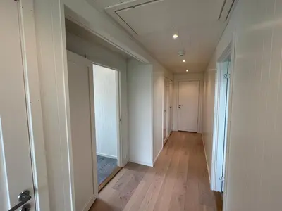 an empty hallway with white walls and wooden floors at Moderne feriehus i Bud in Bud