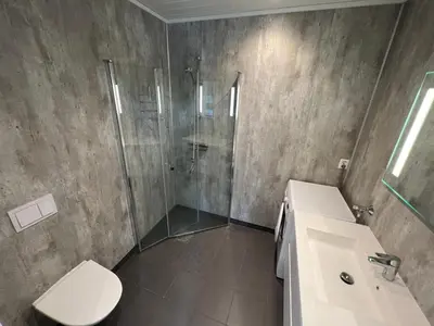 a bathroom with a shower and a toilet and a sink at Moderne feriehus i Bud in Bud
