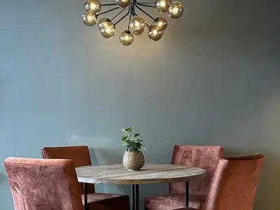 a dining room with a table and chairs and a chandelier at Riddergaardens panorama in Beitostøl
