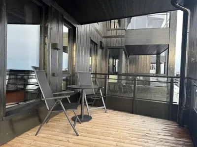 a room with two chairs and a table on a balcony at Riddergaardens panorama in Beitostøl