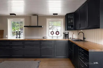 a kitchen with black cabinets and a wooden counter top at Nesfjellet in Nes i Ådal