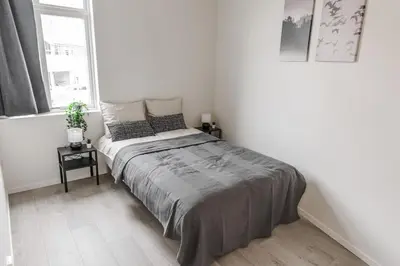 a bedroom with a large bed in a white room at 7 Soverom i hjertet av Bergen in Bergen