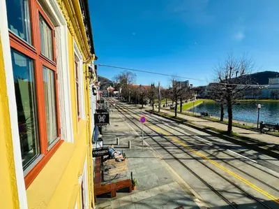 a building with a window and a street with benches at 7 Soverom i hjertet av Bergen in Bergen