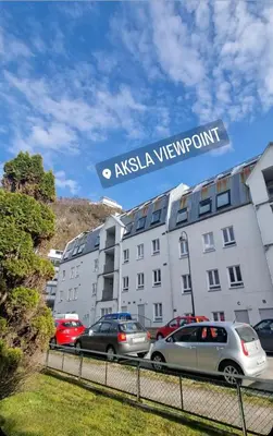 a building with cars parked in a parking lot at Central Apartment Ålesund in Ålesund
