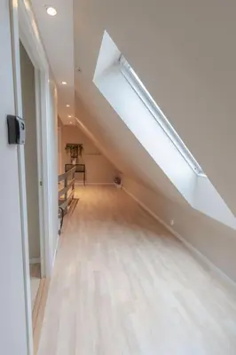 an attic hallway with a staircase with a skylight at Supersentralt Bergen sentrum in Bergen