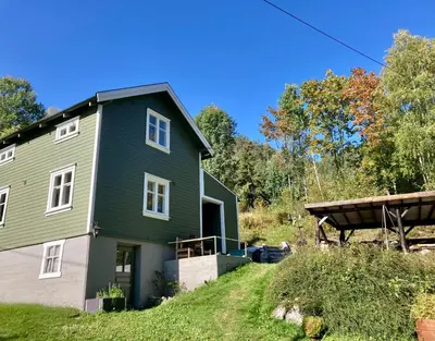 a green house on the side of a hill at Friheten! in Notodden
