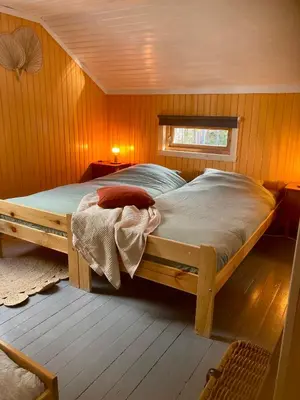 a bedroom with a bed in a wooden room at Friheten! in Notodden