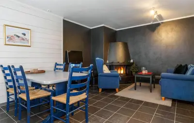 a living room with a table and chairs and a fireplace at Pet Friendly Apartment In Hemsedal in Hemsedal