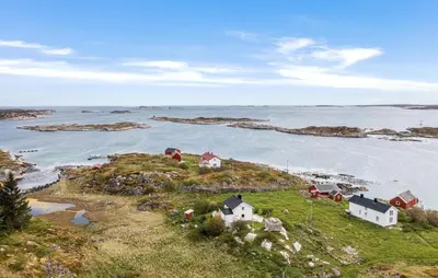 a group of houses on a small island in the water at Cozy Home In Norddyrøy With Kitchen in Sætra