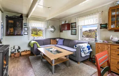 a living room with a couch and a table at Cozy Home In Norddyrøy With Kitchen in Sætra