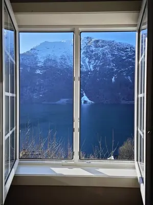 a window with a view of a snowy mountain at Rekkehus Tyssedal Trolltunga in Tveit