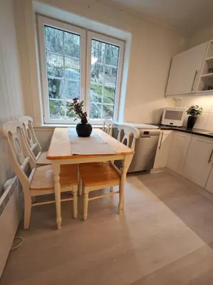 a kitchen with a wooden table and chairs in a kitchen at Rekkehus Tyssedal Trolltunga in Tveit