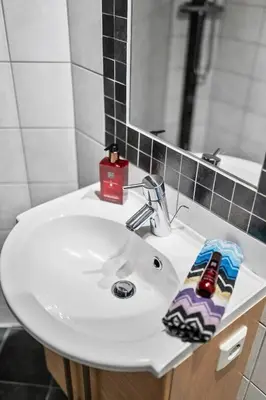 a bathroom with a white sink and a mirror at Modern Apartment In The Heart of Bergen in Bergen